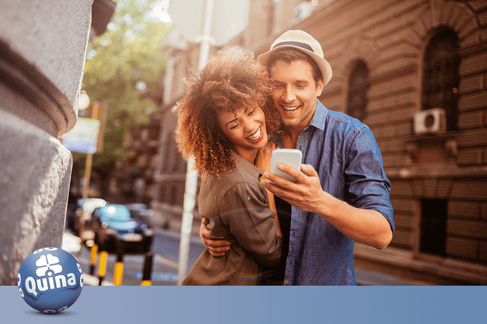 Casal confere no smarthphone como jogar na Quina pela internet