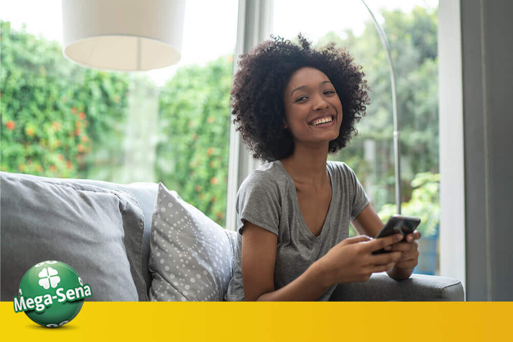 Mulher bonita gerando números aleatórios no celular Mulher bonita gerando números aleatórios de Mega-Sena no celular