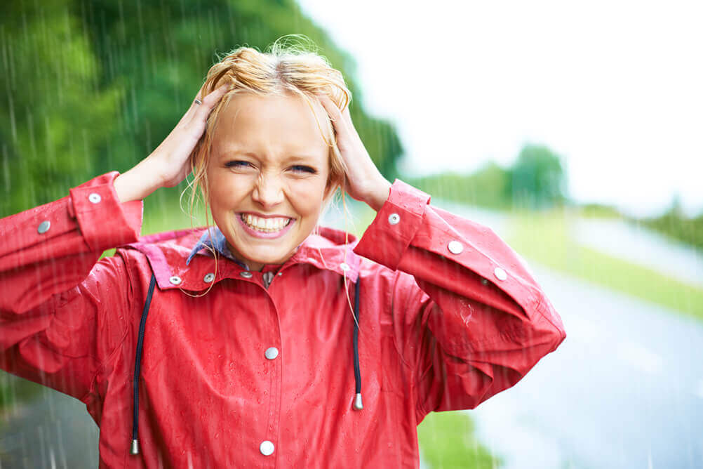 Mulher parada na chuva Mulher loira em meio a uma tempestade chuvosa