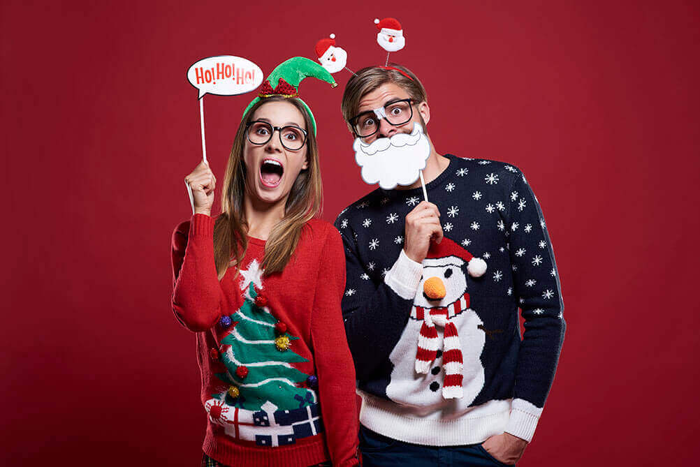 Tradições de Natal em todo o mundo Casal com roupas de Natal celebrando as tradições natalinas