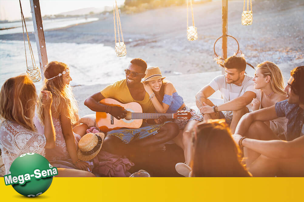 Amigos na praia brincam e discutem dicas para ganhar na Mega Sena.