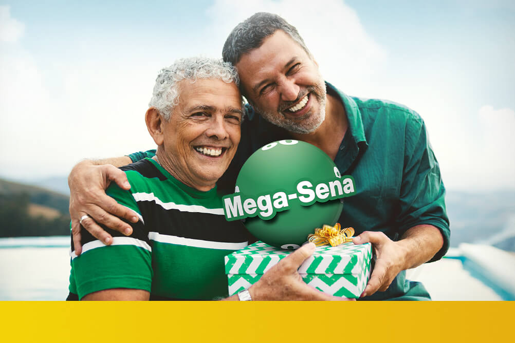 Filho presenteia e abraça o pai no Dia dos Pais, ambos veste uma camisa verde, ao centro a logo da Mega Sena.