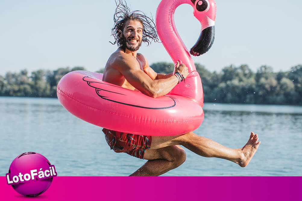 Homem curte férias e pula no lago com boia de flamingo, depois de ganhar seguindo o guia para jogar na Lotofácil.