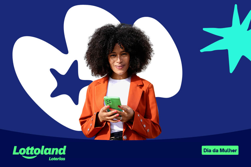 Foto de uma mulher com cabelo black cacheado e terno laranjado segurando um celular com fundo escuro para o Dia Internacional da Mulher.